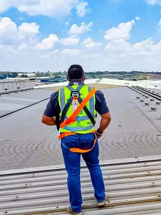 Waterproofing specialist applying a torch-on bituminous membrane system to an industrial flat roof in Gauteng